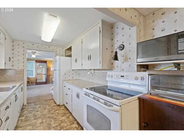 a kitchen with cabinets wooden floor and stainless steel appliances
