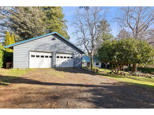 a view of an house with backyard and trees