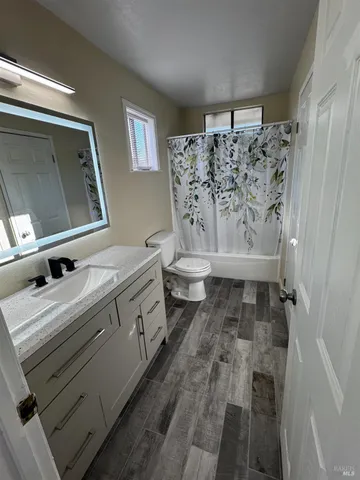 a bathroom with a double vanity sink toilet and mirror