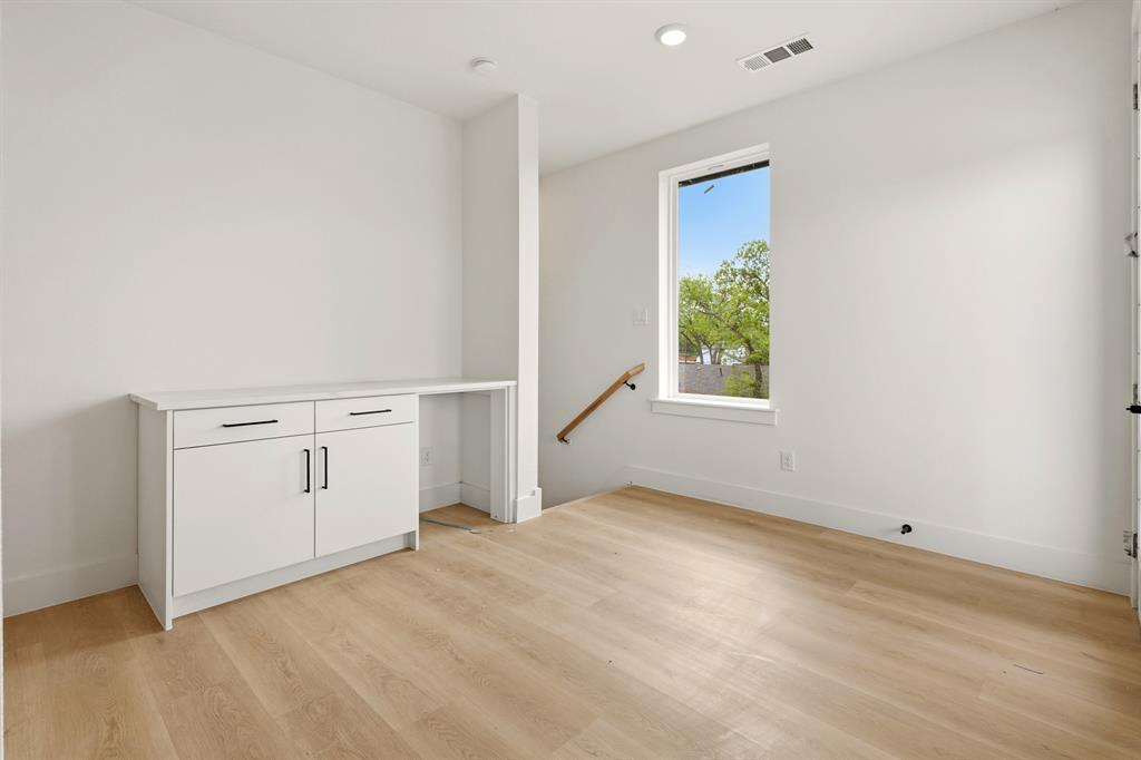 415 North Patton Avenue Dallas, TX 75203 - Photo 18 of 20 This room features light-toned flooring, a built-in cabinet with black hardware, and a window providing natural light