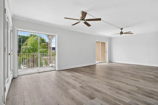 a view of a livingroom with wooden floor and a ceiling fan
