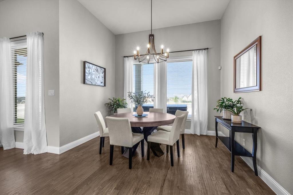 329 Palo Alto Drive Springtown, TX 76082 - Photo 13 of 34 Dining area featuring a contemporary chandelier and two prominent windows with blinds