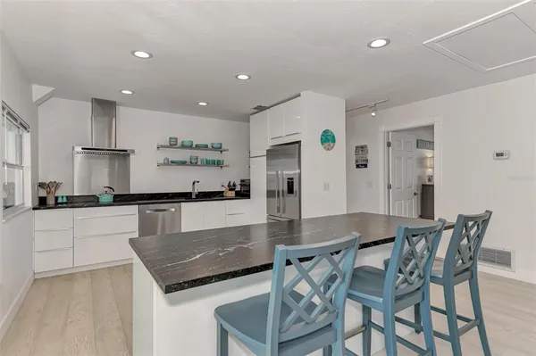 a kitchen with stainless steel appliances granite countertop a sink and refrigerator