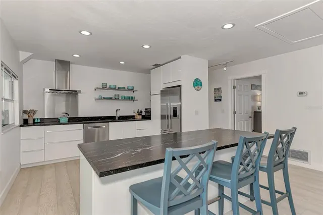 a kitchen with stainless steel appliances granite countertop a sink and refrigerator