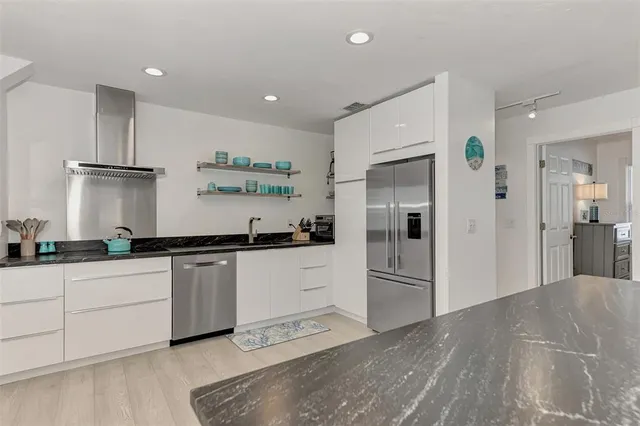 a kitchen with stainless steel appliances granite countertop a stove and cabinets
