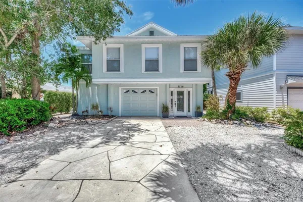 a view of a house with a yard and palm trees
