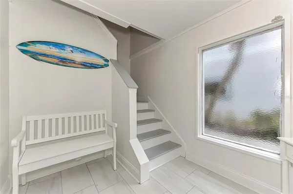 a living room with furniture a flat screen tv and a large window