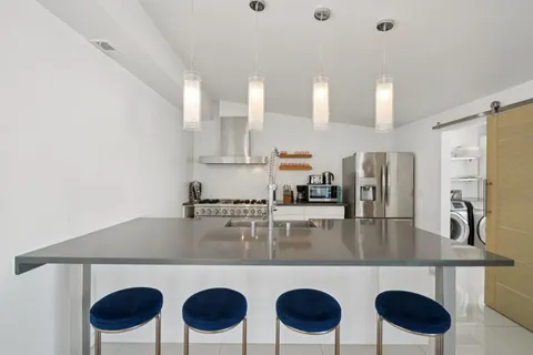 a kitchen with a dining table chairs and a refrigerator