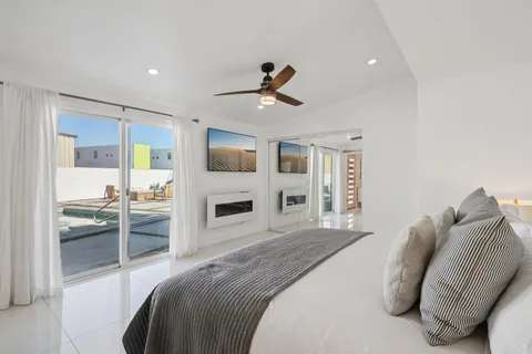 a spacious bedroom with a large bed and a chandelier
