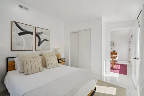 a bedroom with a bed and painting on the wall