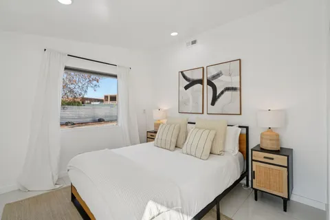 a bedroom with a bed and painting on the wall