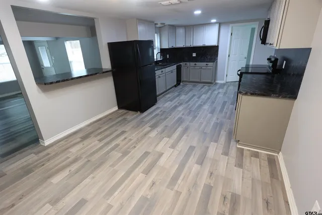 a view of kitchen with refrigerator stove microwave and cabinets