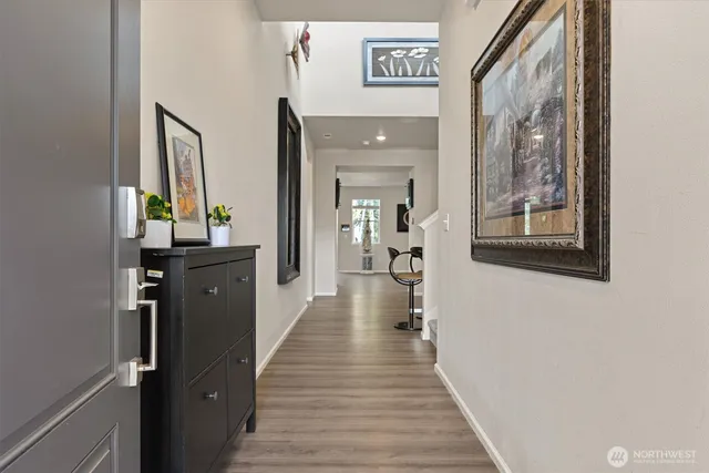 a hallway with a wooden floor and a chandelier