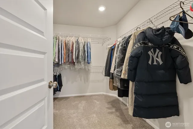a view of walk in closet with clothes and shoes