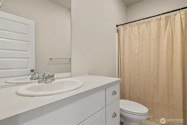 a bathroom with a sink toilet and a mirror