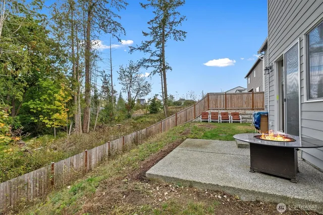 a view of a patio with table and chairs with wooden fence