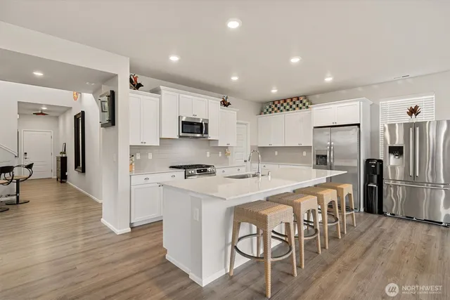 a kitchen with stainless steel appliances a refrigerator stove microwave and cabinets