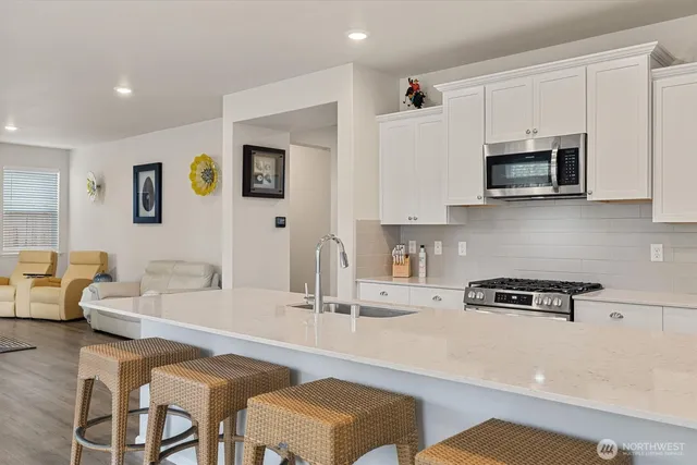 a kitchen with stainless steel appliances a microwave a stove and white cabinets