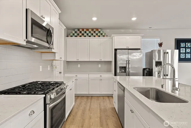 a kitchen with stainless steel appliances a sink stove and cabinets