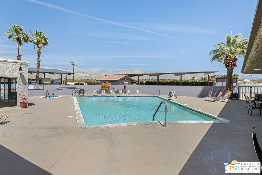18555 Roberts Road, Unit 103 Desert Hot Springs, CA 92241 - Photo 29 of 30 a view of a swimming pool with a table and chairs
