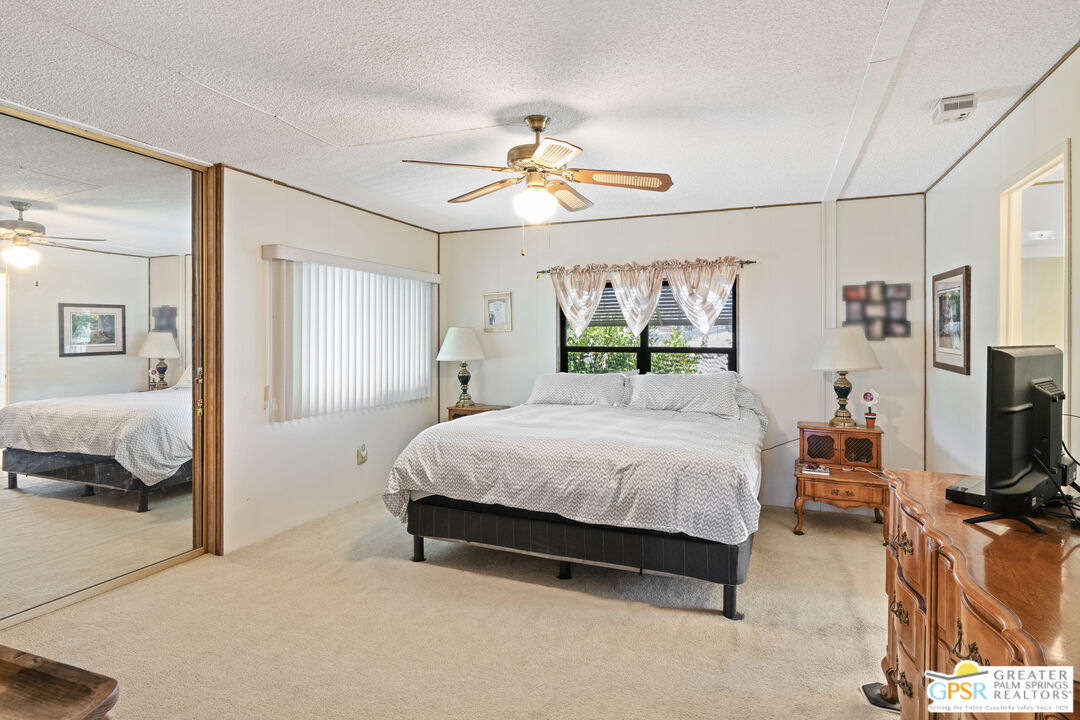 18555 Roberts Road, Unit 103 Desert Hot Springs, CA 92241 - Photo 3 of 30 a bedroom with a bed and a flat tv screen