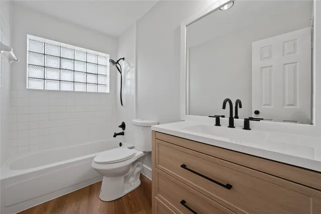 a spacious bathroom with a granite countertop sink a mirror and a bathtub