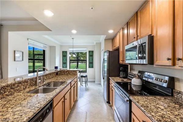 a kitchen with stainless steel appliances granite countertop a sink a stove and a wooden floors