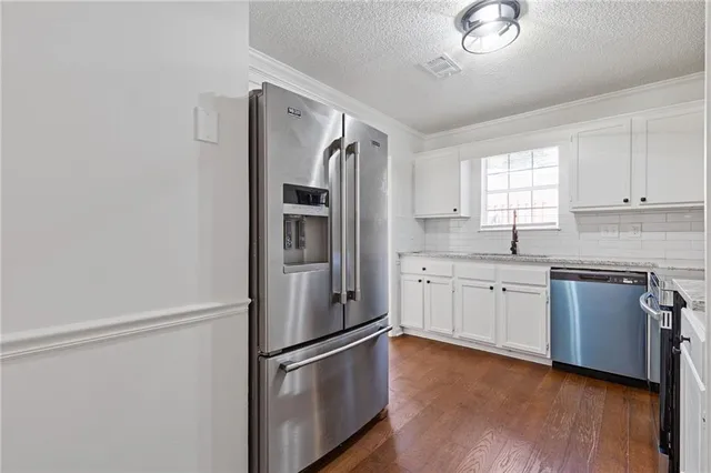 a kitchen with a sink cabinets stainless steel appliances and a window