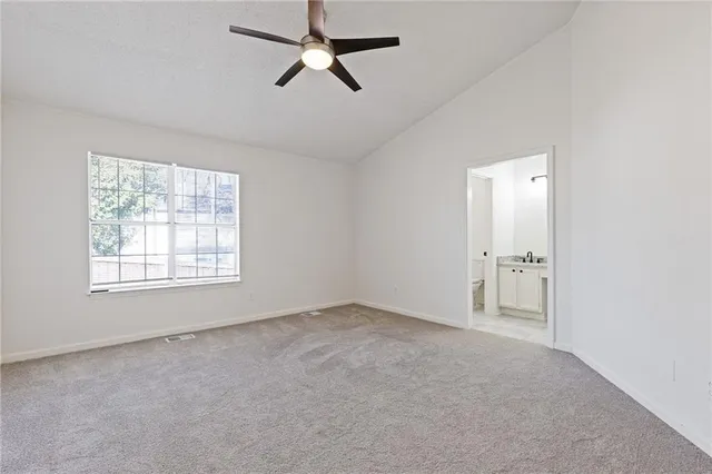 an empty room with a chandelier fan