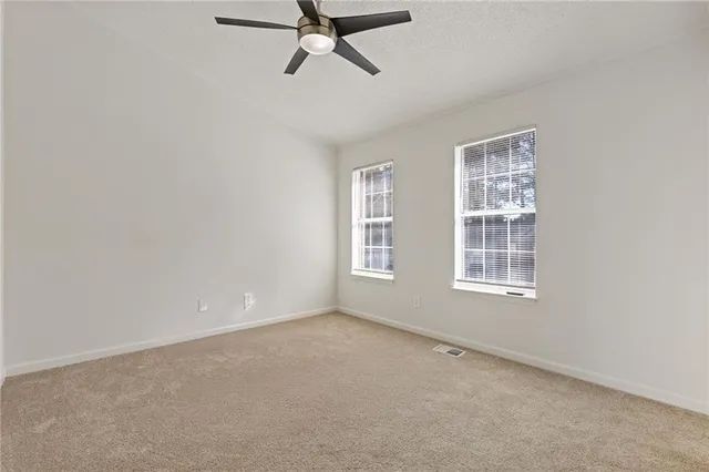 an empty room with a ceiling fan and entryway