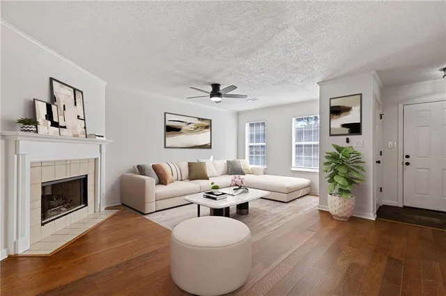 an empty room with wooden floor fireplace and windows