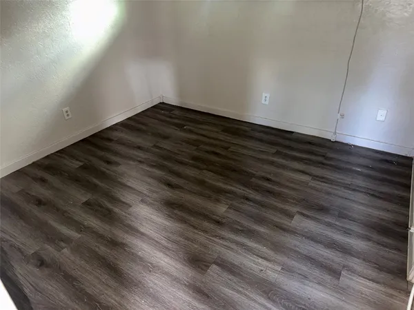 a view of an empty room and wooden floor