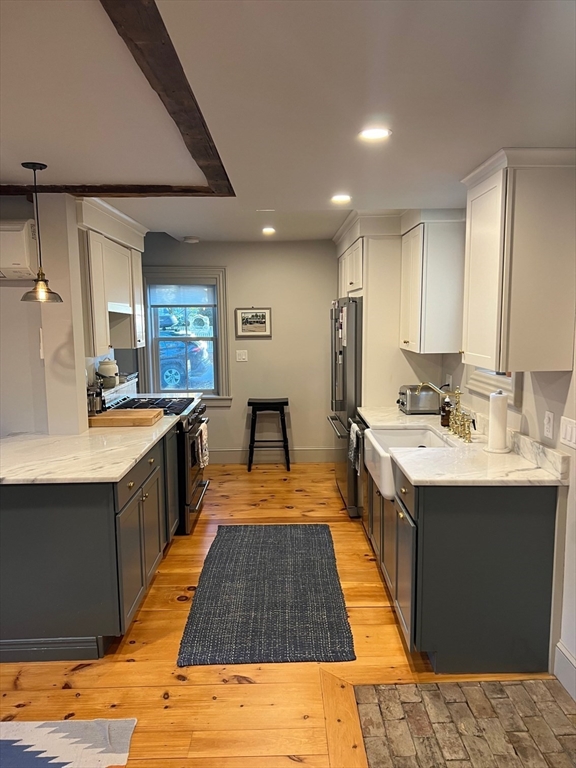 32 Buffum Street, Unit 1 Salem, MA 01970 - Photo 5 of 19 a large kitchen with kitchen island a sink stainless steel appliances and cabinets