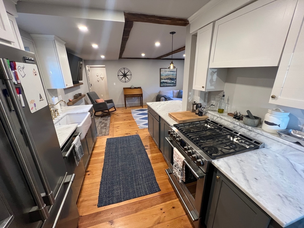 32 Buffum Street, Unit 1 Salem, MA 01970 - Photo 6 of 19 a kitchen with granite countertop a stove and a sink