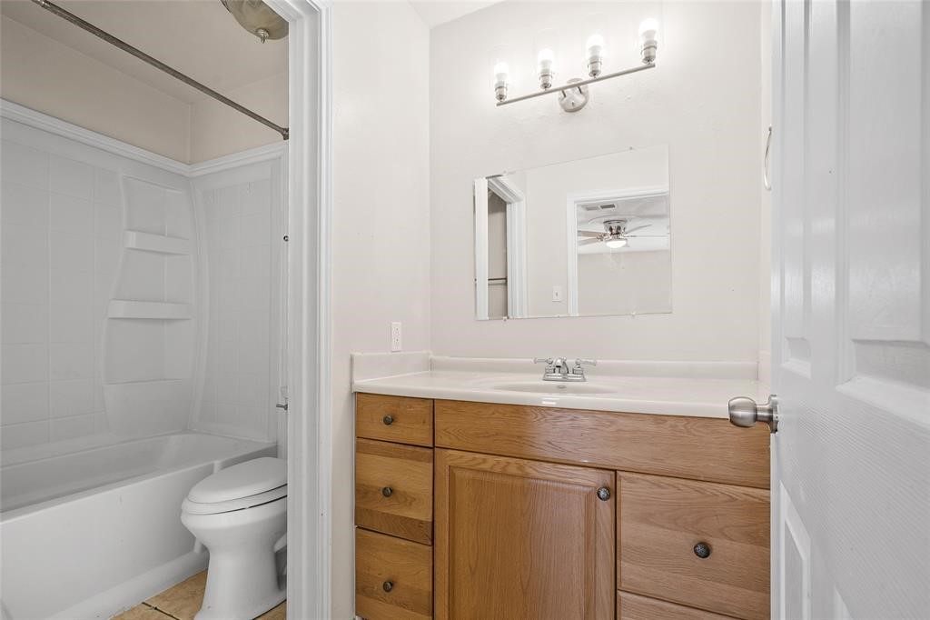 328 South 2nd Street, Unit 330 Alvin, TX 77511 - Photo 12 of 15 a bathroom with a granite countertop sink a toilet and shower