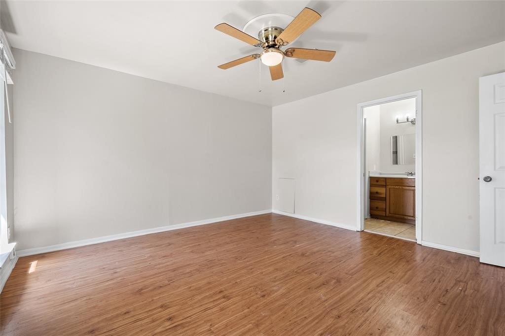 328 South 2nd Street, Unit 330 Alvin, TX 77511 - Photo 7 of 15 an empty room with wooden floor and ceiling fan