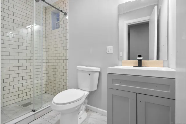 a bathroom with a sink a toilet and shower