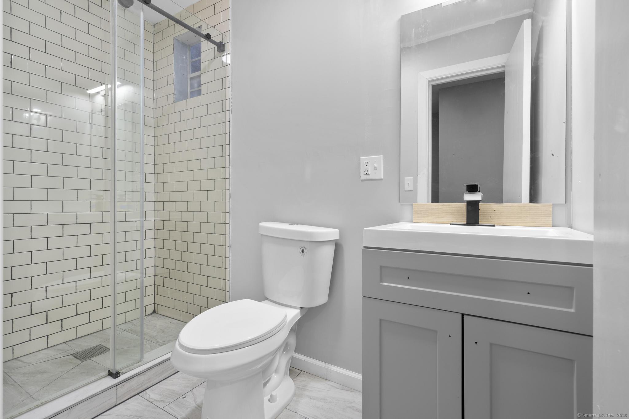 140 Grand Street, Unit 2C Waterbury, CT 06702 - Photo 12 of 13 a bathroom with a sink a toilet and shower