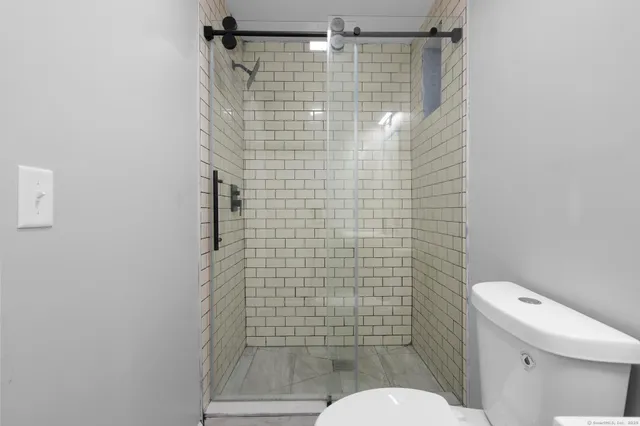 a bathroom with a shower toilet and sink