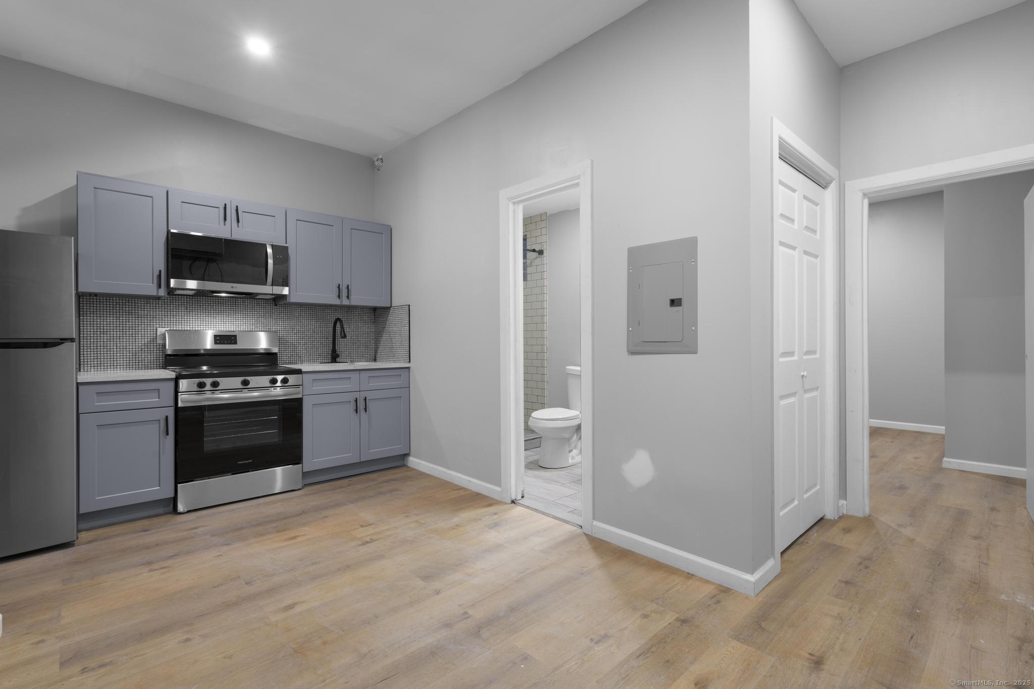 140 Grand Street, Unit 2C Waterbury, CT 06702 - Photo 6 of 13 a kitchen with stainless steel appliances a refrigerator stove and microwave