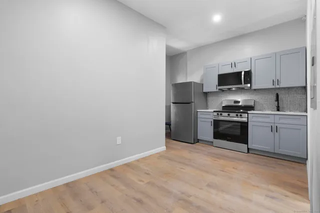 a kitchen with granite countertop a refrigerator stove and microwave