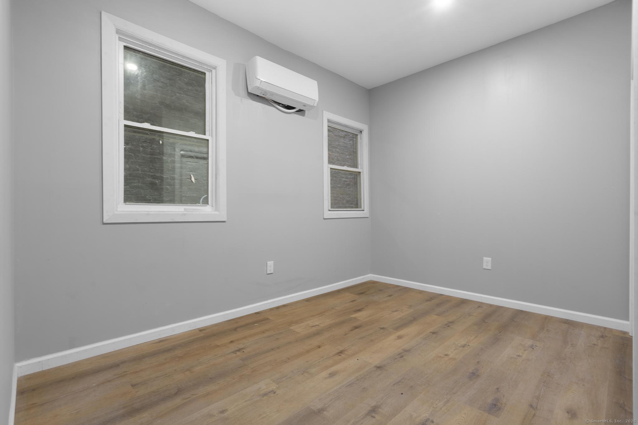 140 Grand Street, Unit 2C Waterbury, CT 06702 - Photo 10 of 13 a view of an empty room with wooden floor and a window