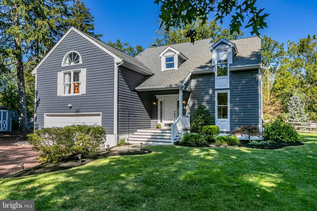 a front view of a house with a yard and trees