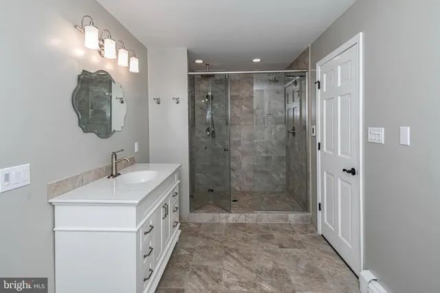 a bathroom with a double vanity sink mirror and shower