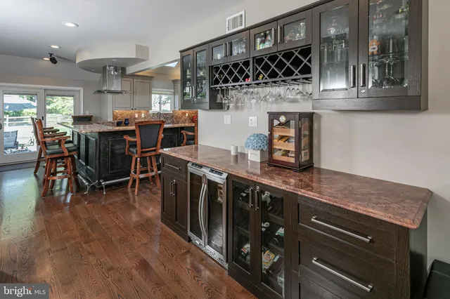 a kitchen with stainless steel appliances granite countertop a lot of counter space and wooden floors