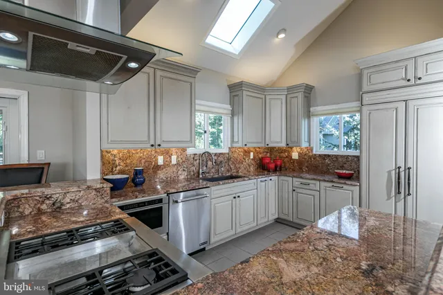 a kitchen with stainless steel appliances granite countertop a stove and a sink