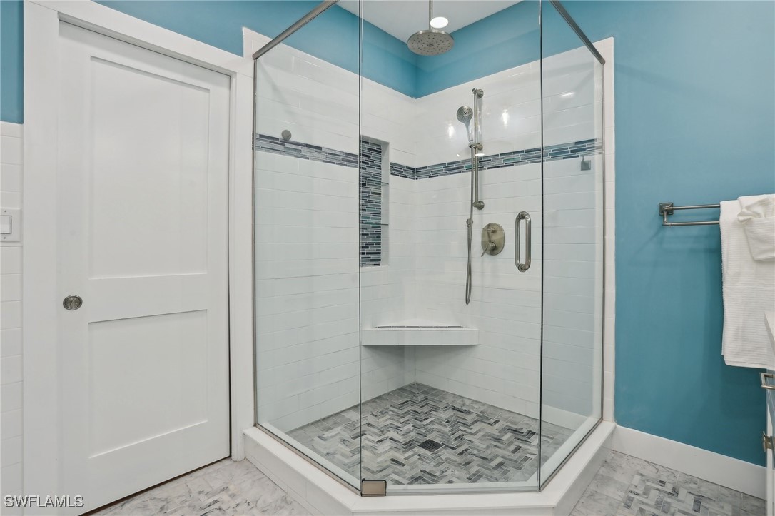 8335 Main Street Bokeelia, FL 33922 - Photo 35 of 47 a bathroom with a glass shower door and a bathtub