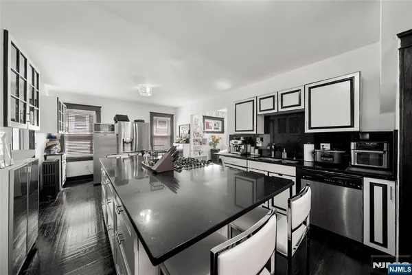 a large kitchen with stainless steel appliances granite countertop lots of counter top space and center island