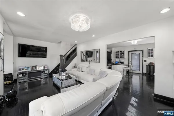 a living room with furniture kitchen view and a flat screen tv