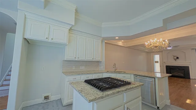 a kitchen with granite countertop a sink stove and cabinets
